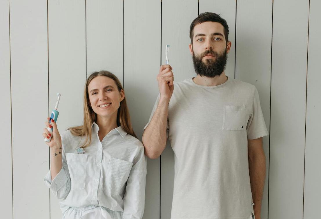 Man and woman holding toothbrushes