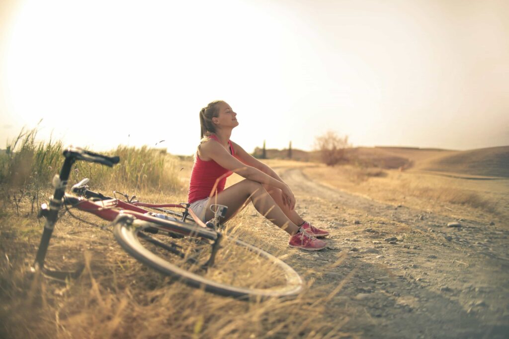woman sitting next to bike breathing heavy